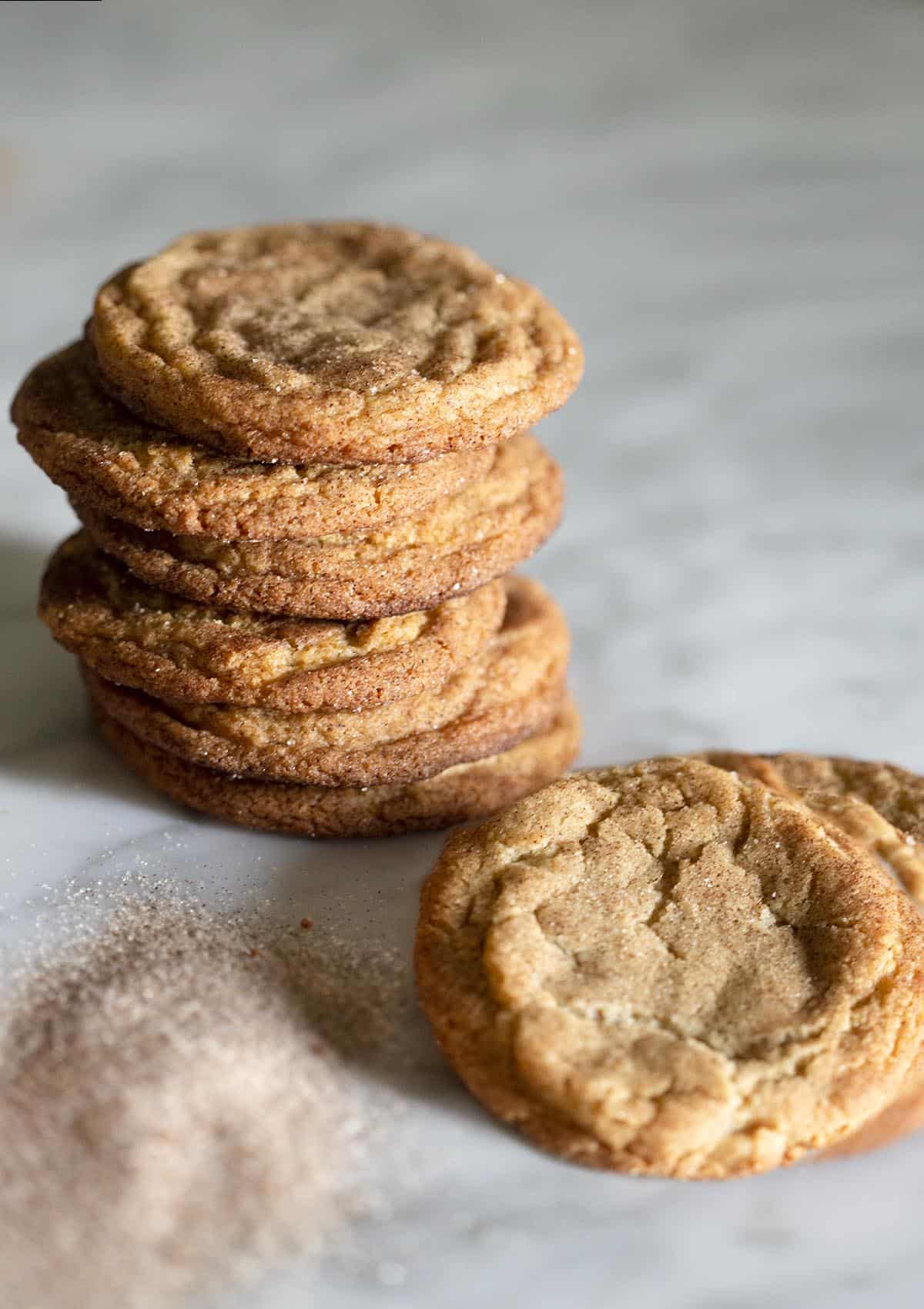 A stack of snickerdoodle cookies on a marble counter.