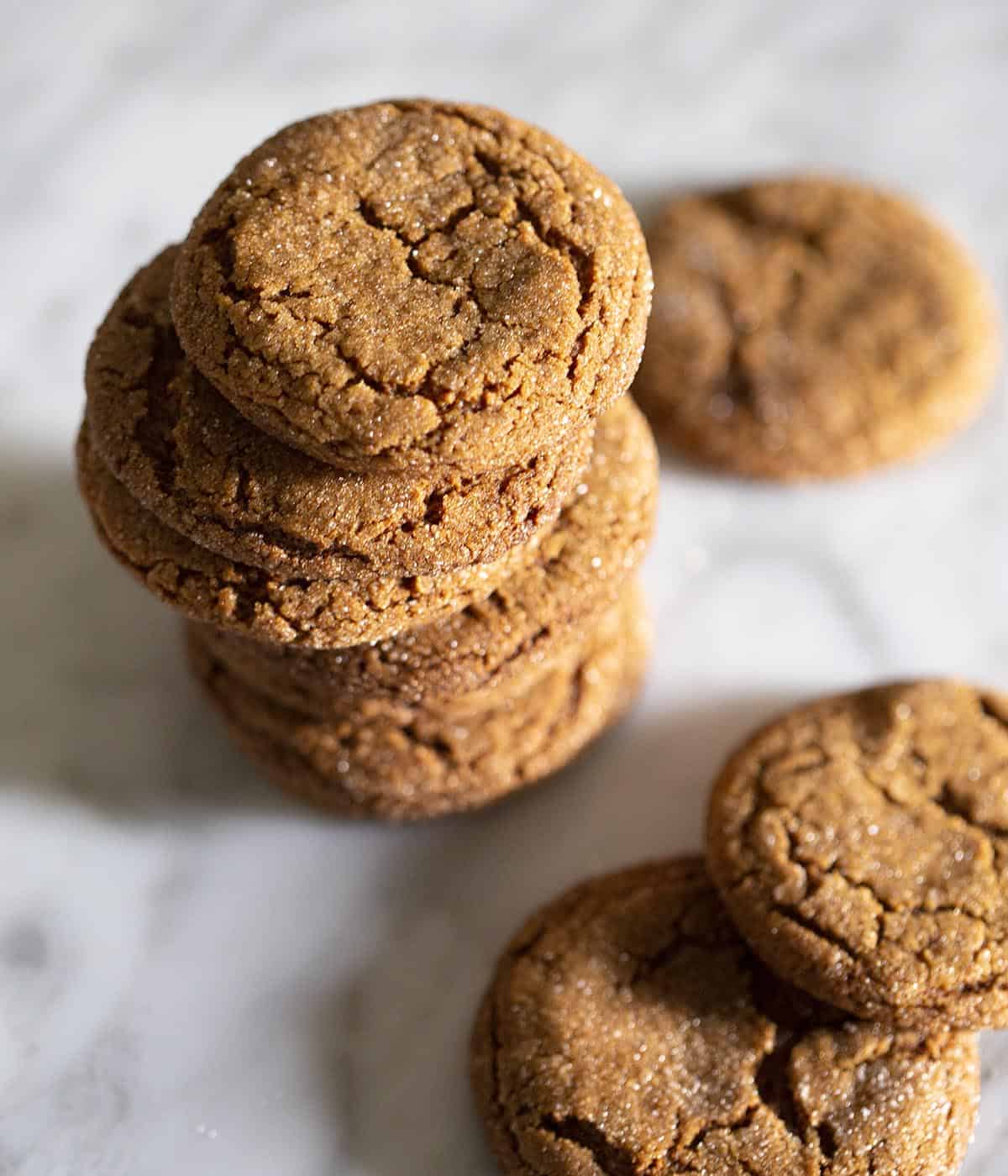 Molasses cookies stacked on a marble table.