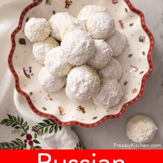 several russian tea cakes on a plate decorated with a christmas scene