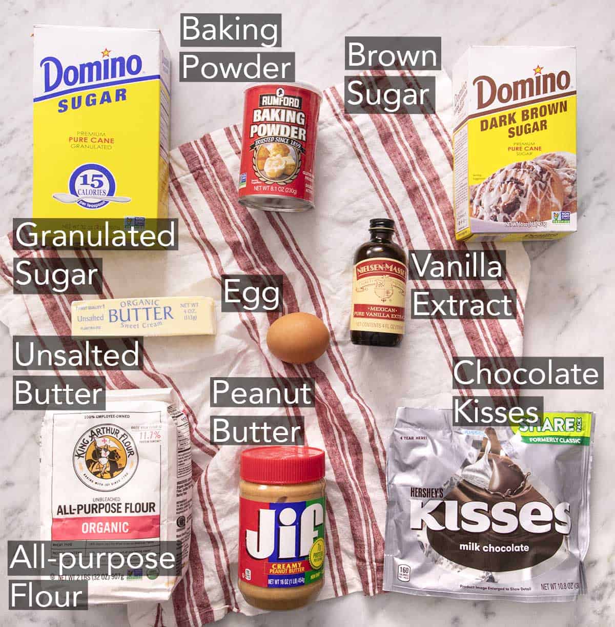 Ingredients to make peanut butter blossoms on a striped linen napkin.