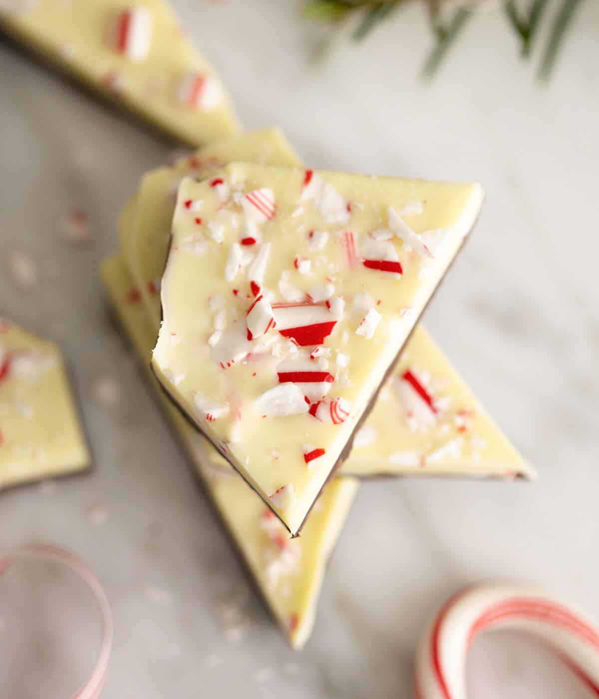 A top down photo of pieces of peppermint bark flecked with crushed candy cane pieces.