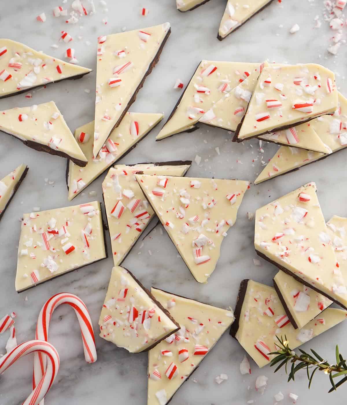 Triangular peppermint bark pieces on a marble counter. 