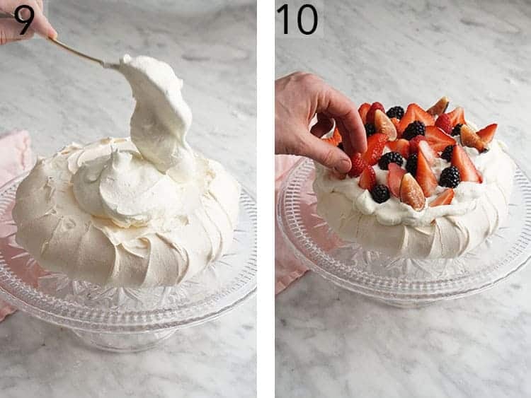 Whipped cream and berries getting placed on a meringue disk to finish a Pavlova