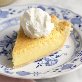 A piece of buttermilk pie on a blue and white plate.