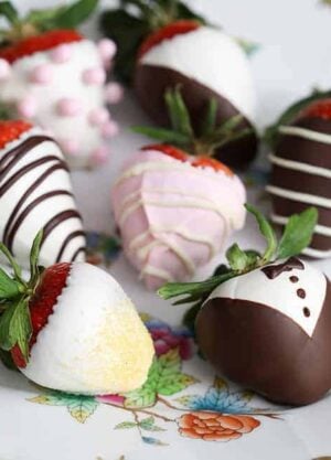 Various types of chocolate covered strawberries mare with white and dark chocolate on a plate