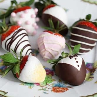 Various types of chocolate covered strawberries mare with white and dark chocolate on a plate