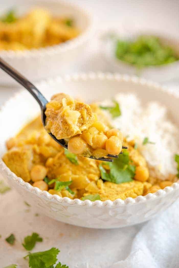 A close up of chicken curry on a fork