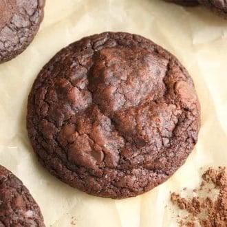 A top down shoot of a chocolate brownie cookie on a piece of parchment paper.