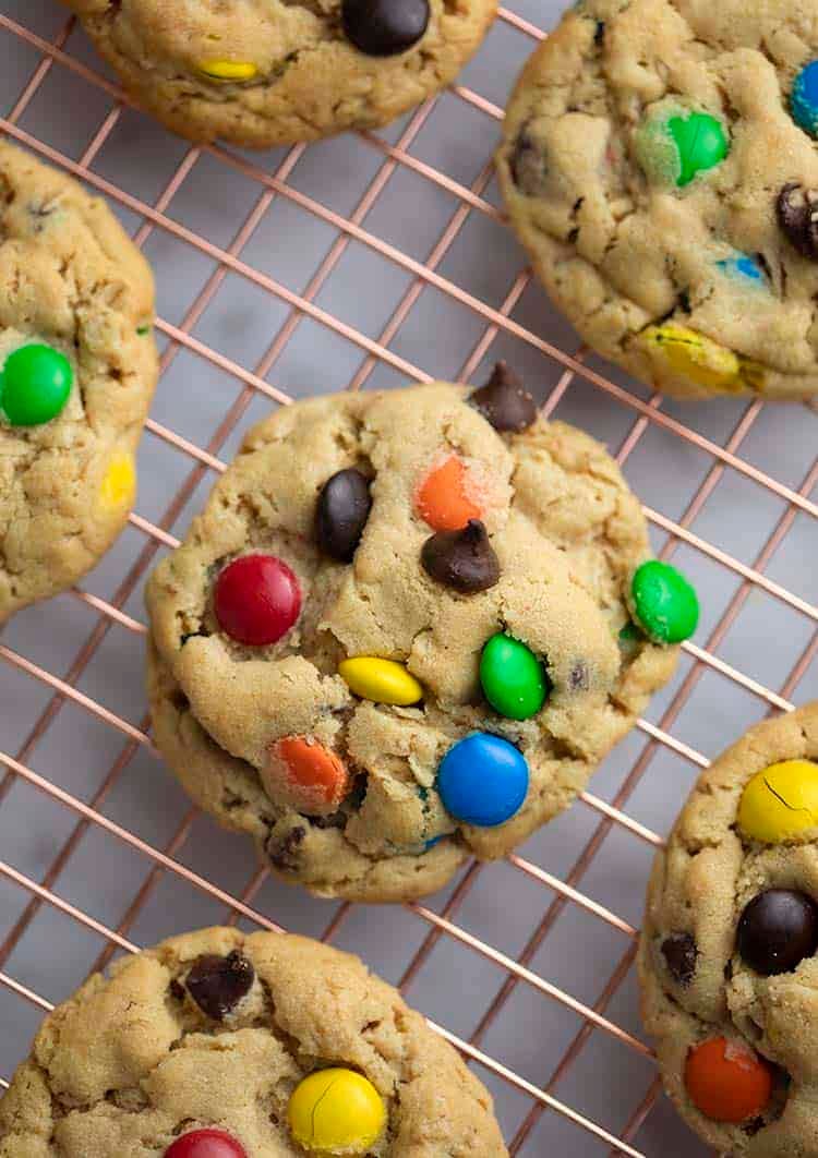 a close up top down photo of a monster cookie on a cooling rack.