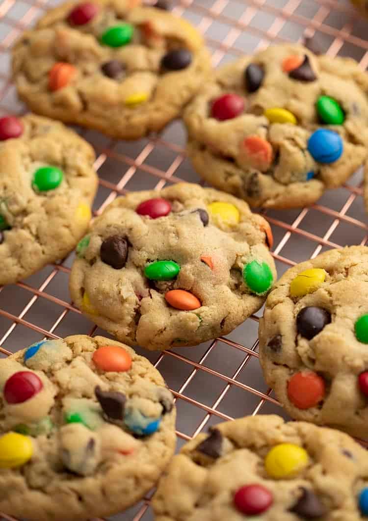 Monster cookies on a copper cooling rack.
