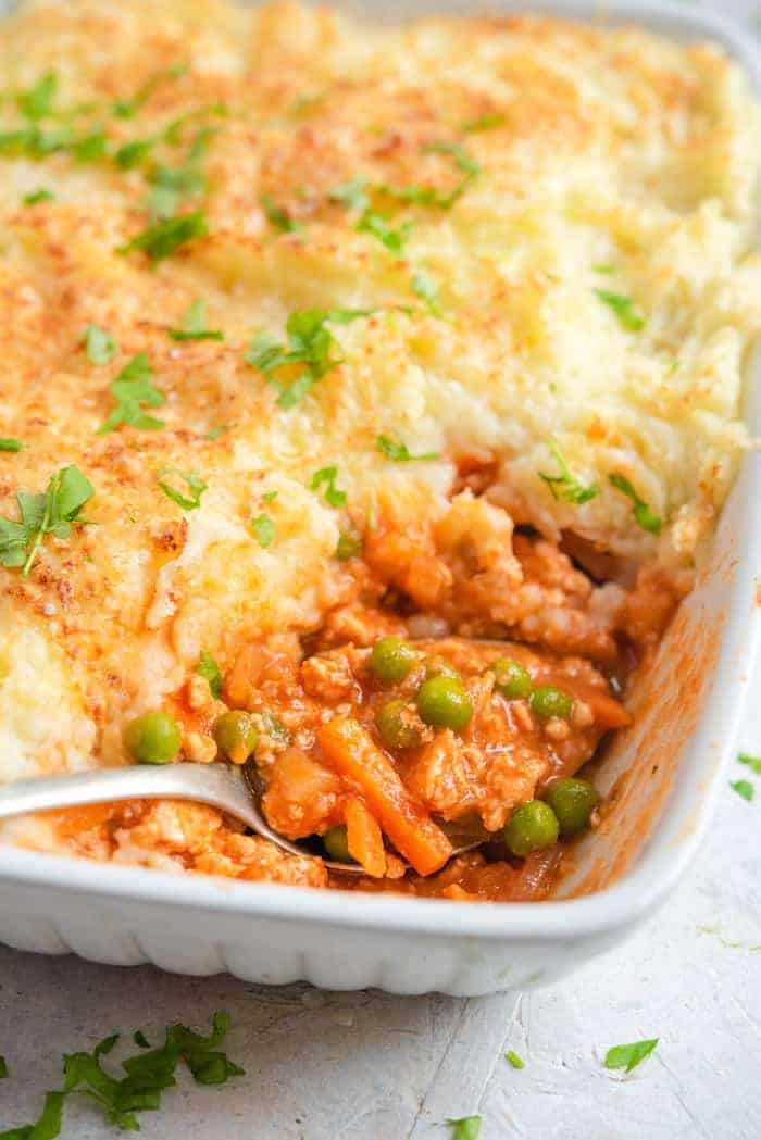 A close up of a shepherds pie with a scoop removed