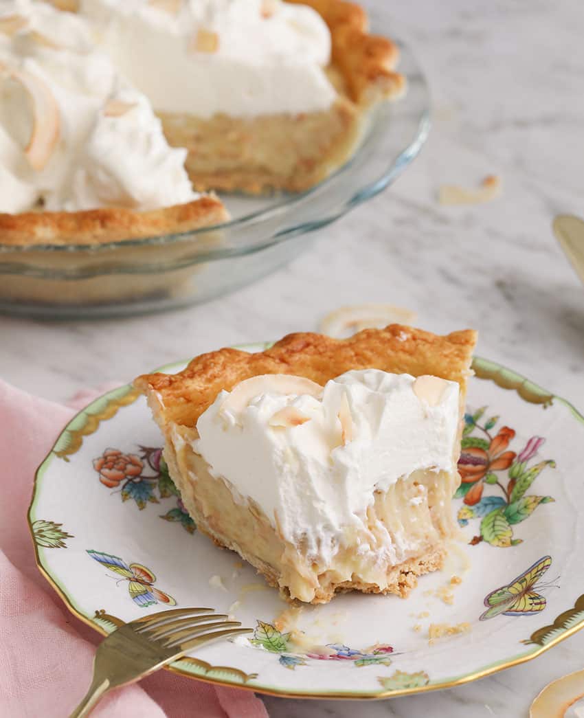 A Pice of coocnut cream pie that's been partially eaten.