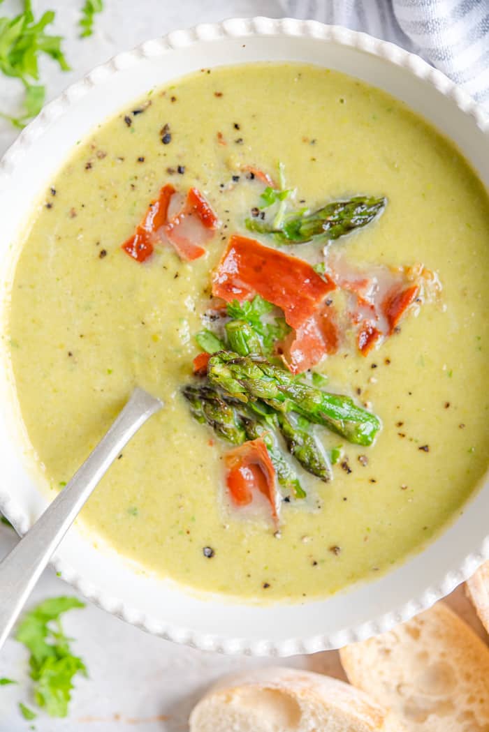 A close up of asparagus soup in a bowl with a spoon