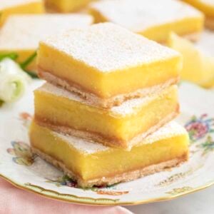 A stack of lemon bars on a porcelain plate.