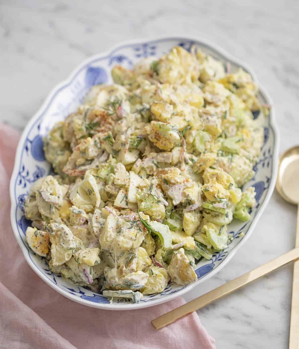 A potato salad in a blue and white serving dish.