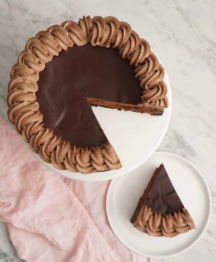 A top down photo of a chocolate cheesecake with a piece removed and on a plate next to it.