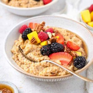 A bowl of Instant Pot steel cut oats with an assortment of toppings with a spoon inside.
