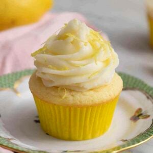 A lemon cupcake on a porcelain plate.