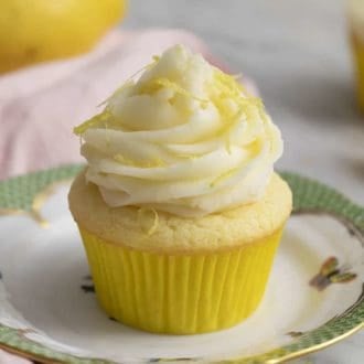 A lemon cupcake on a porcelain plate.