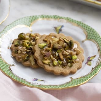 Two baklava cookies on a green and white plate.