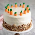 A close up of a carrot cake on a cake stand