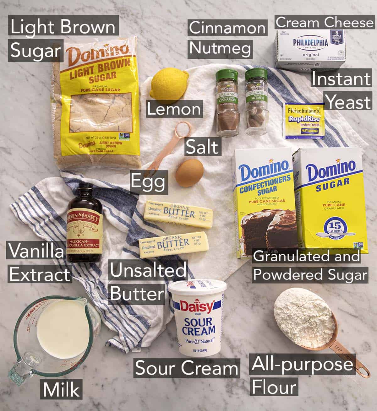 Ingredients to make cinnamon rolls on a marble counter.