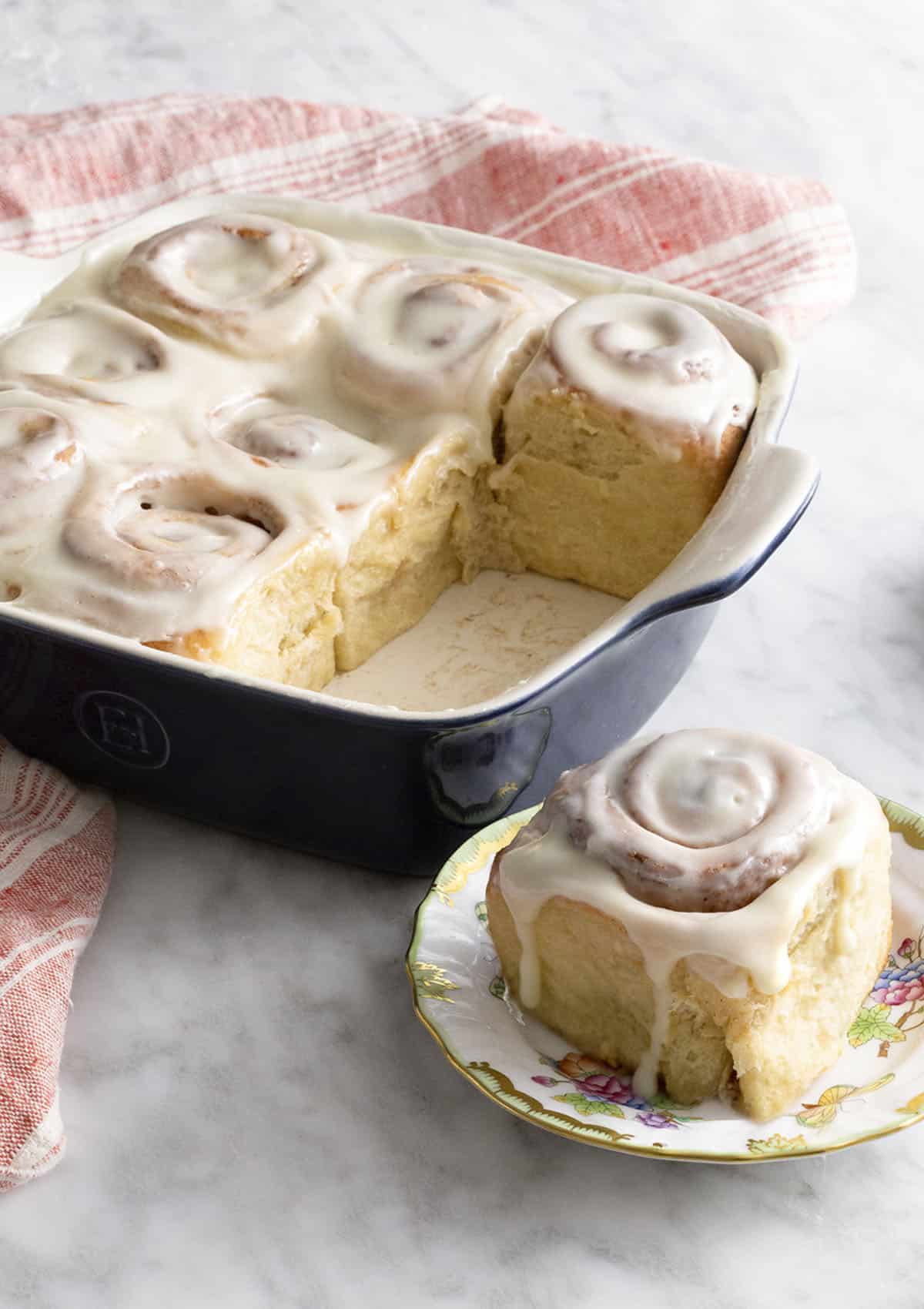 Freshly baked cinnamon rolls on a marble counter.