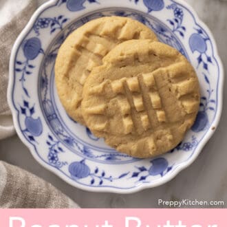 Two peanut butter cookies on a blue and white plate.