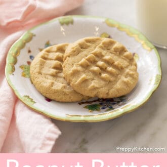 Two peanut butter cookies on a porcelain plate.
