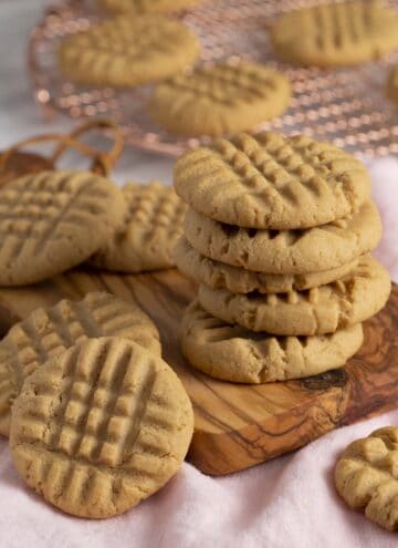 A stack of peanut butter cookies on a small wooden board