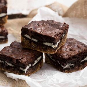 Three slutty brownies on a piece of parchment paper.