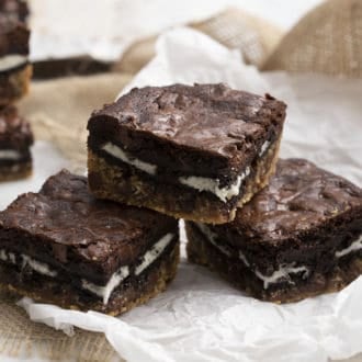 Three slutty brownies on a piece of parchment paper.