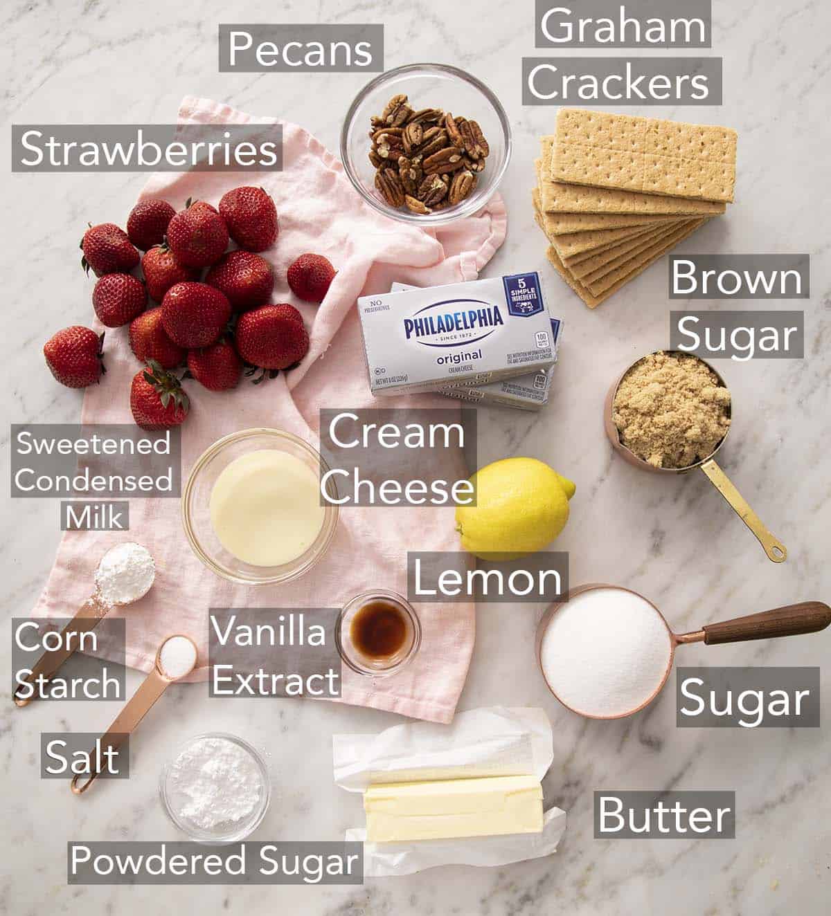 Ingredients for making a no bake strawberry cheesecake on a counter.