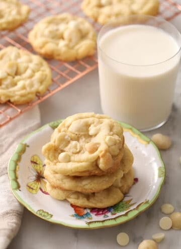 three white chocolate macadamia nut cookies stacked on a plate
