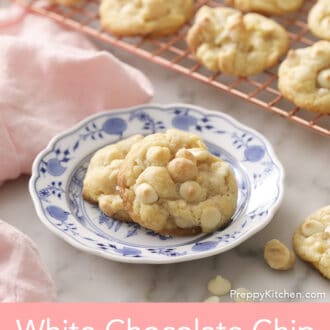White chocolate chip macadamia nut cookies on a plate next to a pink napkin.
