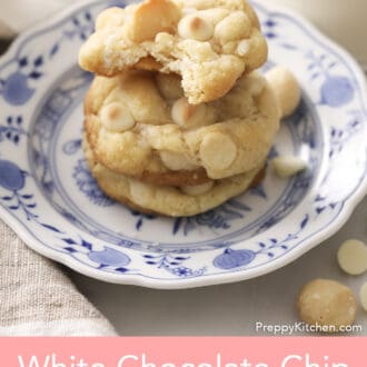 Three White chocolate chip macadamia nut cookies with the top one having a bite taken out.