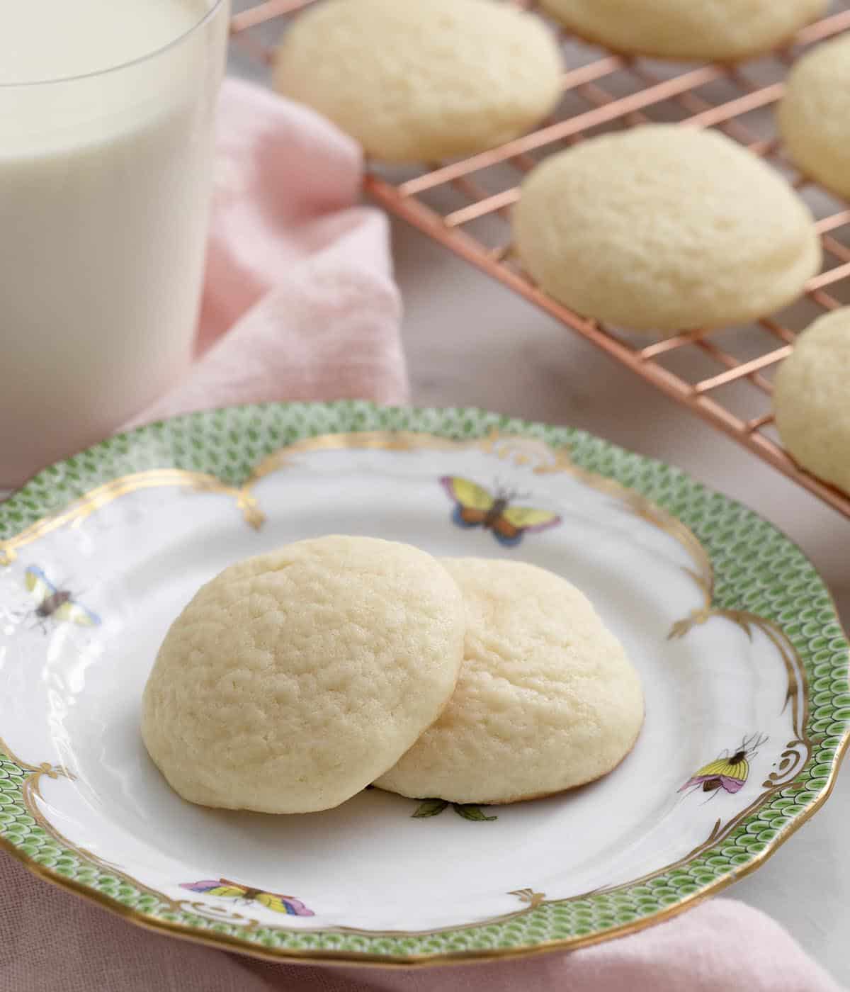 Two cream cheese cookies on a porcelain plate ready to be eaten. 
