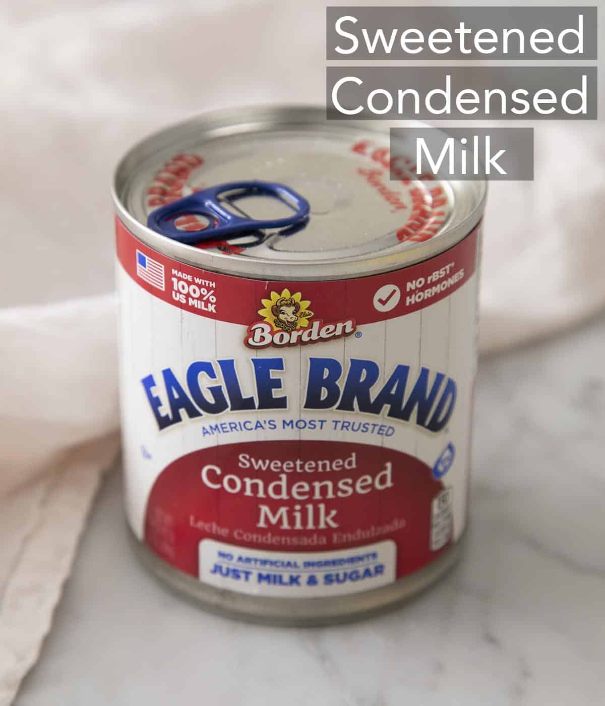 A can of sweetened condensed milk on a marble counter.
