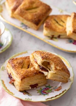 pastelitos de guayaba on a place next to a cup of coffee.