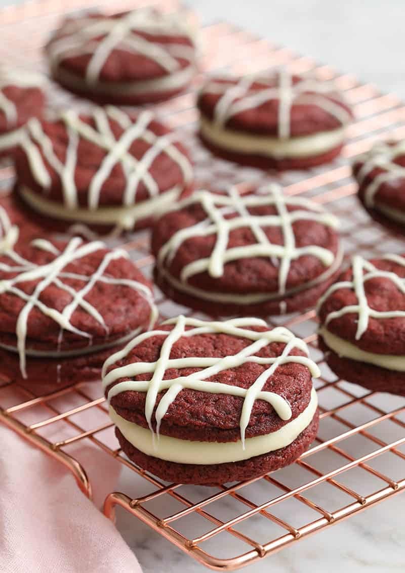 Red velvet cookies arranged on a copper wire rack.