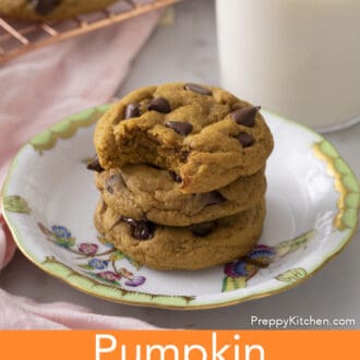 A stack of three delicious pumpkin chocolate chip cookies on a porcelain plate.