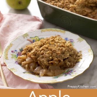 Pinterest graphic of a serving of apple crisp on a porcelain plate with a baking dish in the background.