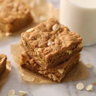Blondies with white chocolate chips on a marble table.