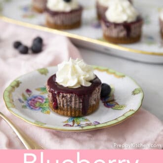 Several mini blueberry cheesecakes next to a pink linen napkin.