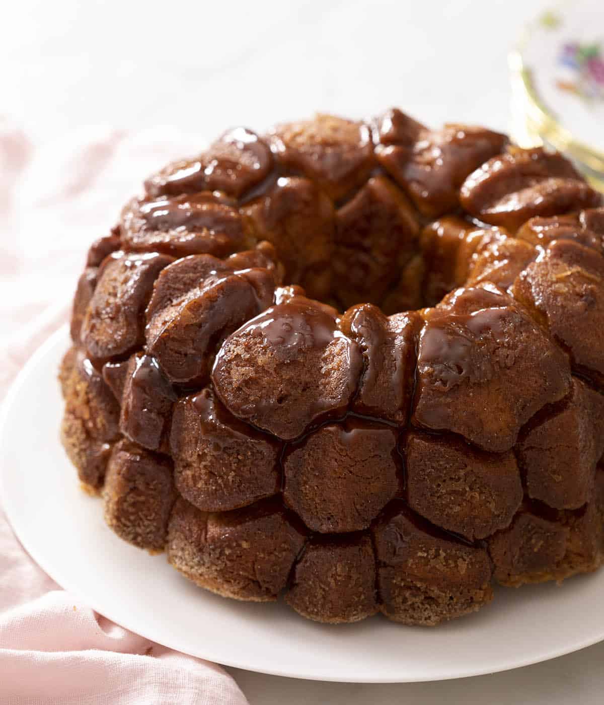 Monkey bread glistening with caramel on a plate.