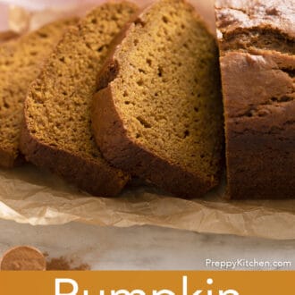 Pinterest graphic of a loaf of sliced pumpkin bread on parchment paper.