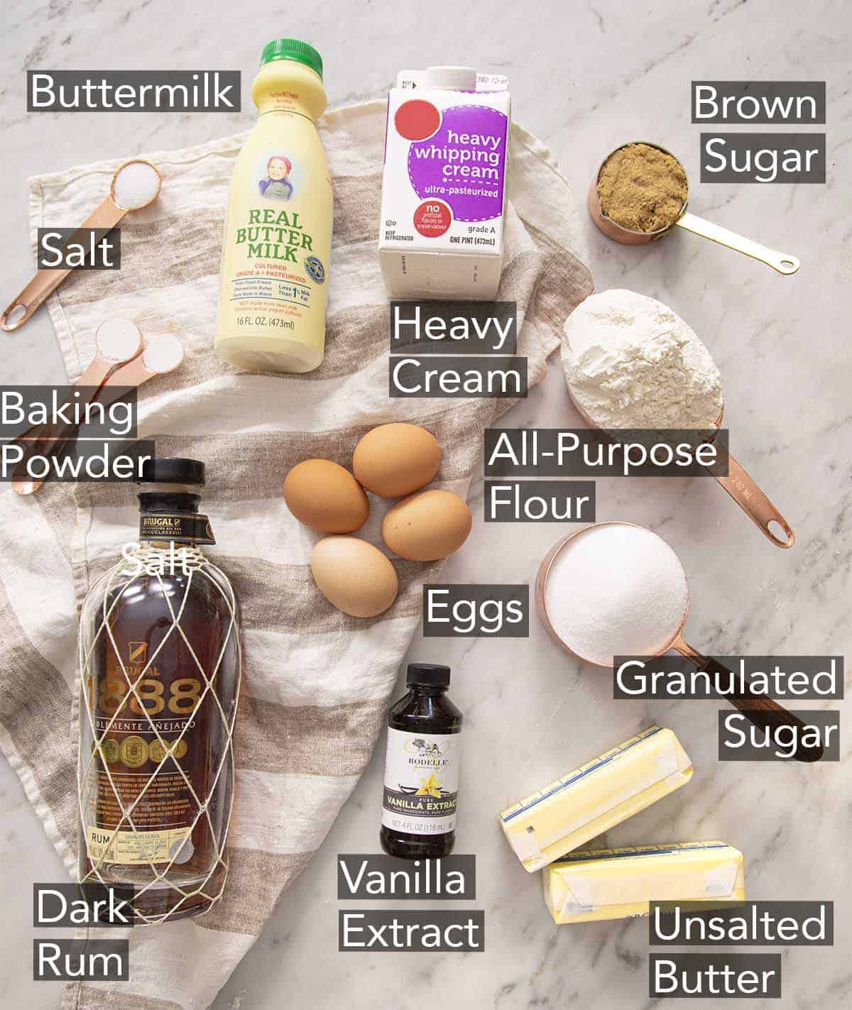 Ingredients to make a rum cake on a marble counter.