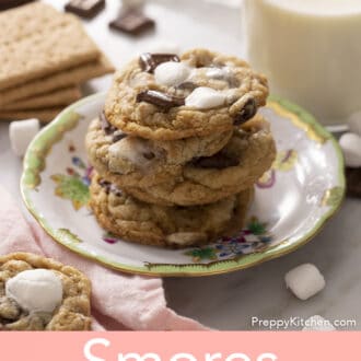 Three smores cookies on a plate next to a glass of milk.