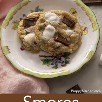Two s'mores cookies on a porcelain plate next to a napkin.