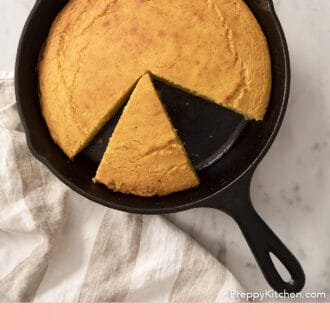 An iron skillet of cornbread on a marble counter.